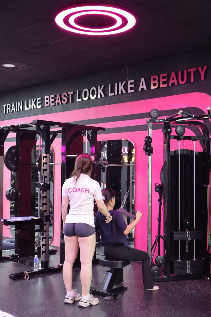 Huấn luyện viên nữ hướng dẫn học viên tập gym 1 kèm 1 tại MS.PI Women Fitness Bình Dương.